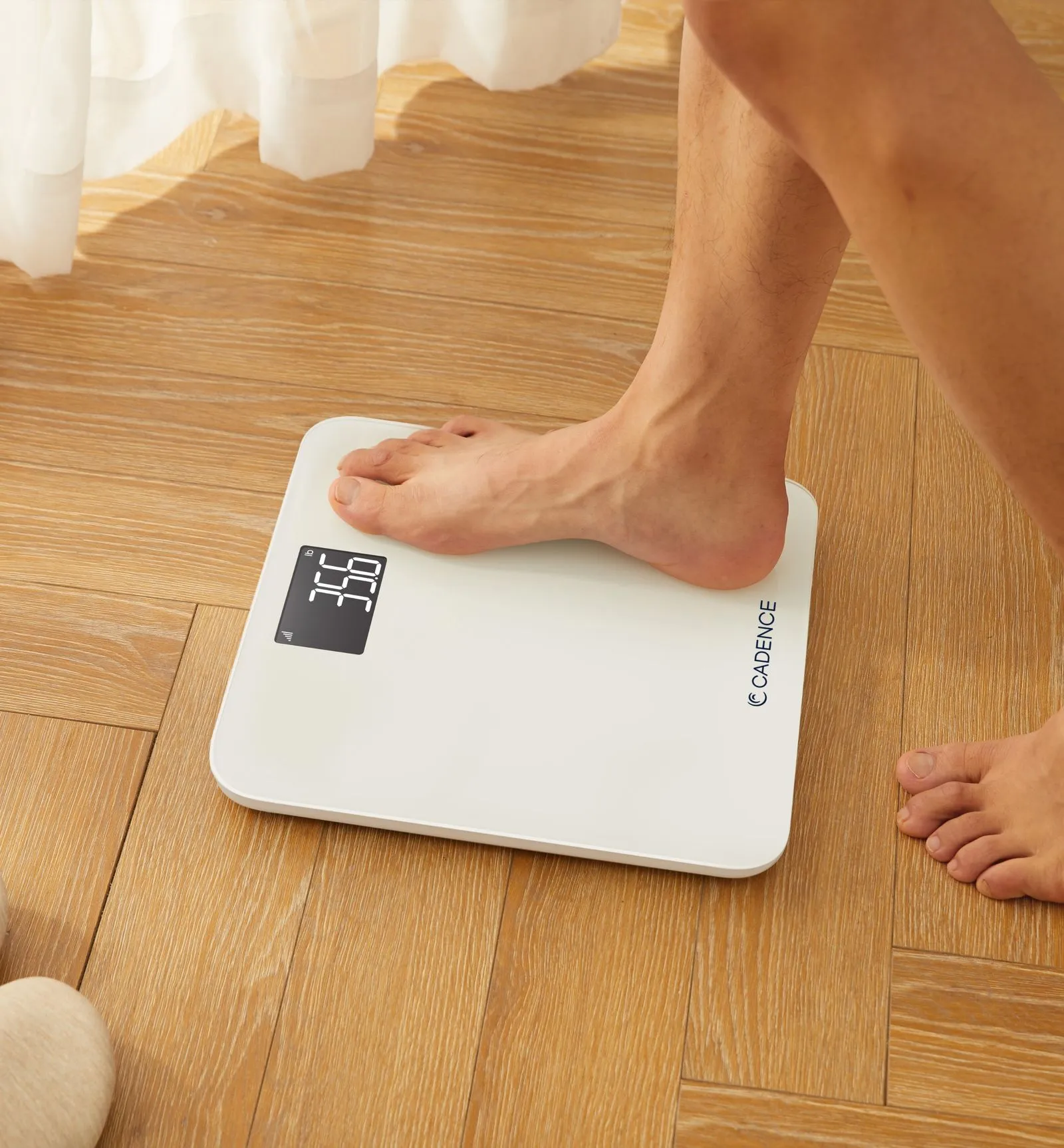 A foot steps onto a scale with the Cadence logo on it