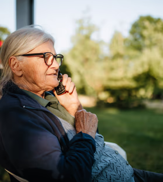 older woman on phone with health provider outside