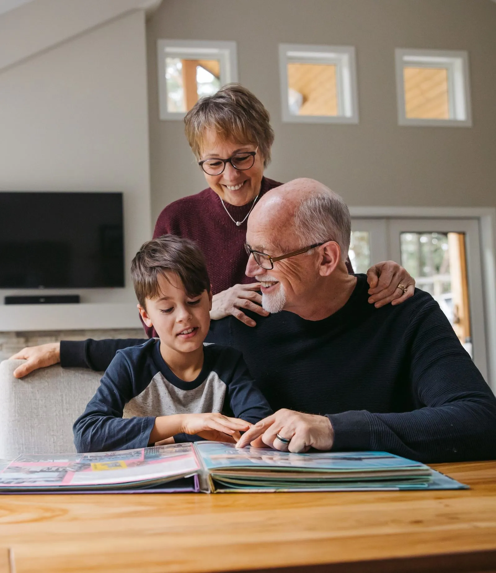 Older couple teaching their grandson from a book