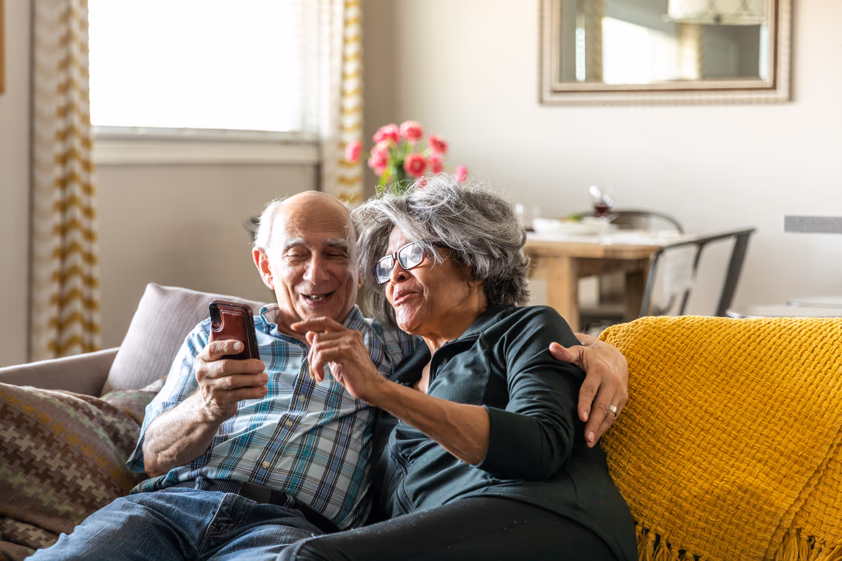 Older couple scheduling care plan appointment with their provider using their phone